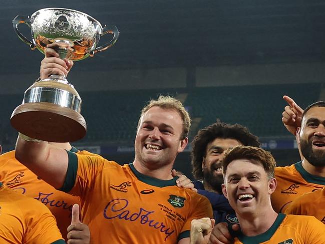 Australia's captain Harry Wilson holds the Ella-Mobbs Trophy as Australia's players pose after their win in the Autumn Nations Series International rugby union test match between England and Australia at the Allianz Stadium, Twickenham in south-west London, on November 9, 2024. Australia won the game 42-37. (Photo by Adrian Dennis / AFP)