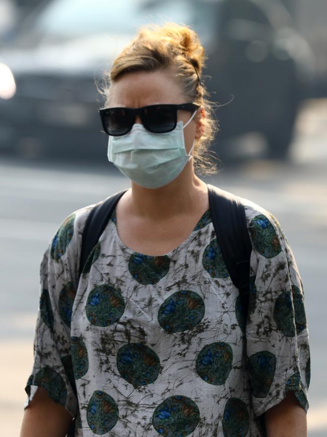 As smoke from bushfires engulfs Sydney, morning commuters are pictured wearing face masks as they make their way to work. Picture: MATRIX