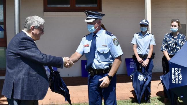 Rotary District Governor Jeff Egan presents the new umbrellas to Superintendent Scott Tanner in Ballina on Friday.