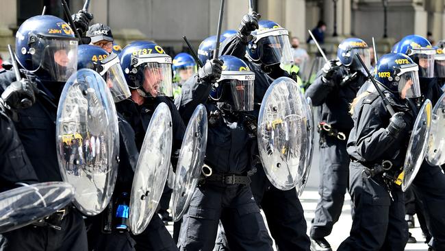 Police in riot gear gesture with batons during protests in Liverpool on Saturday. Picture: AFP