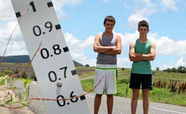 Travis Lowe, 14 (left) and Brad Austin, 17 along with their friend Josh Mazzaracca, 20 helped a woman restart her car after it was ruined by floodwaters at Freestone. Picture: Kirstin Payne 