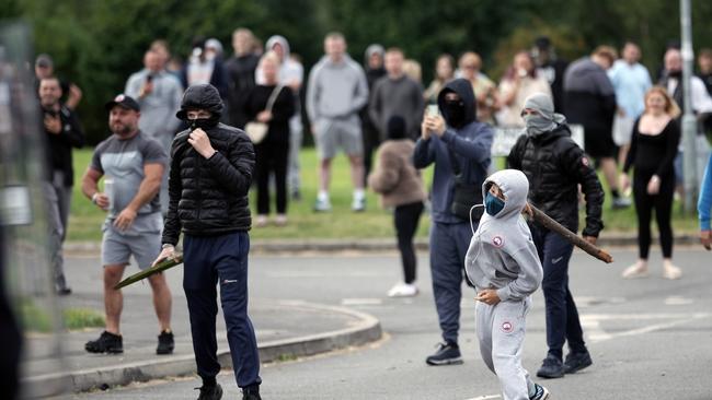 Children were among anti-migration rioters throwing objects toward police in Rotherham on Sunday. Picture: Getty Images