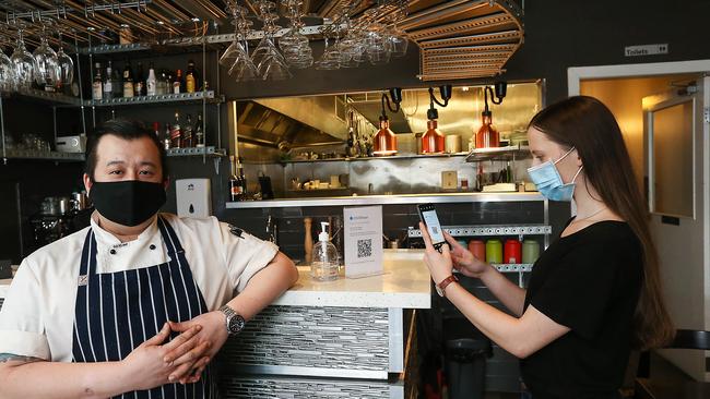 Imbue Food and Wine Restaurant owner Phong Nguyen looks on as Lisa Kowal scans her phone using COVIDTracer technology. Picture : NCA / NewsWire / Ian Currie