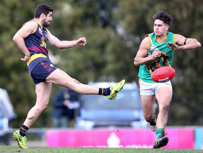 Nick Batsanis, left, of Doncaster East, kicks past Aaron Beddoes of Mooroolbark. Picture: Hamish Blair