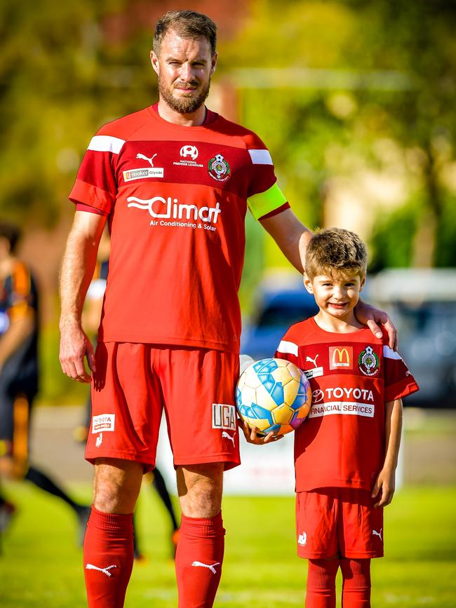 Campbelltown City captain Iain Fyfe with son Lennon, 6, before an NPL match. Fyfe impressed coach Joe Mullen in the 0-0 draw with Para Hills. Picture: Ken Carter