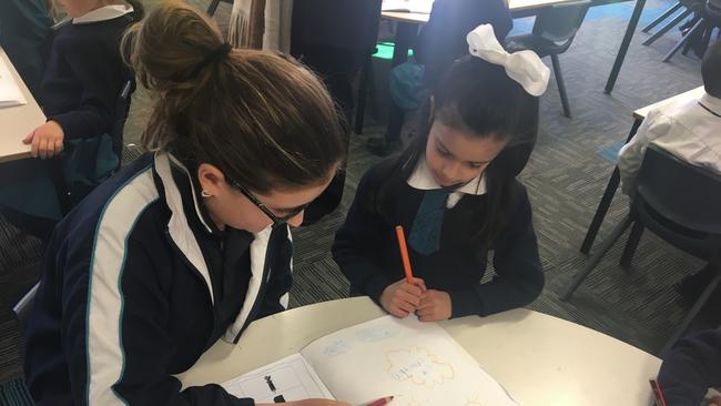 DoSomething Day 2017: Our lady of the angels primary at Rouse Hill: Ella Owen (Yr 5) is helping Charlotte Naim (kindy) with her writing