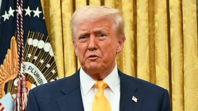 A poster with a map captionned "Gulf of America" is seen as US President Donald Trump speaks by the signed commission to make Howard Lutnick US Secretary of Commerce sitting on the Resolute Desk in the Oval Office of the White House in Washington, DC, on February 21, 2025. (Photo by Jim WATSON / AFP)