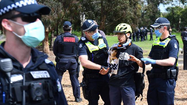 Police detain an anti-lockdown protester in Elsternwick.