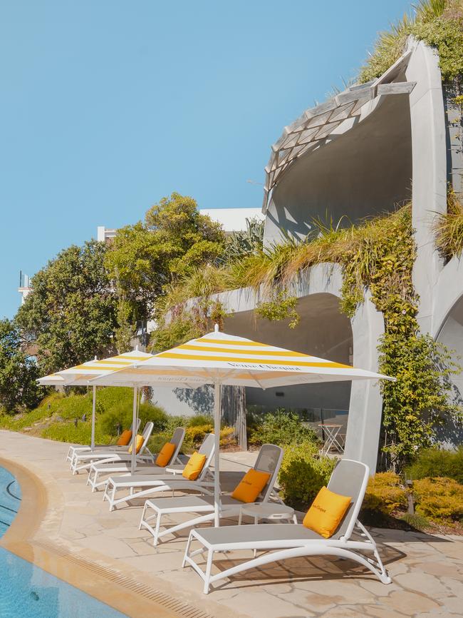 Jaunty yellow and white striped pool umbrellas line the pool. Picture: James Vodicka.