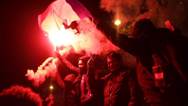 A football fans holds a smoke flare after France's victory over Morocco