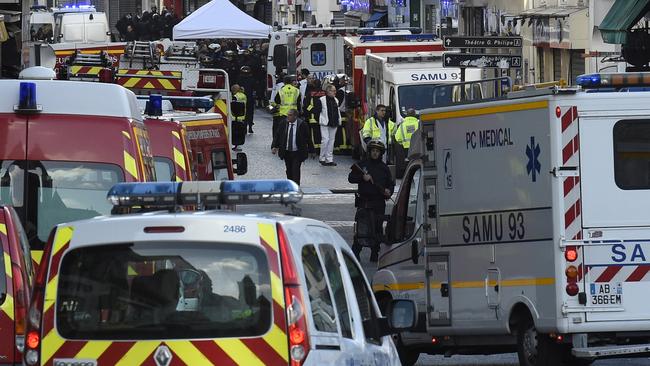 Policemen stand guard in Saint-Denis as the raids take place. Picture: AFP.