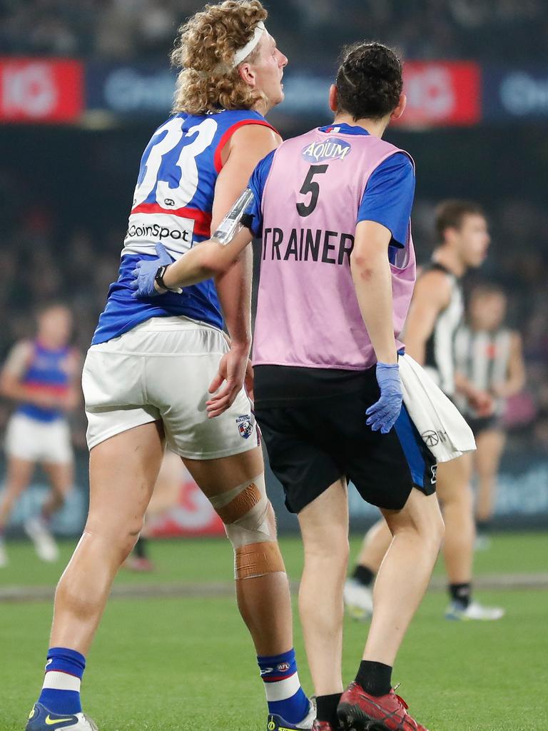 Naughton speaks with a trainer after hurting himself. Picture: Michael Willson/AFL Photos via Getty Images