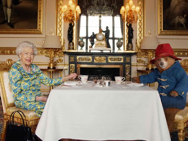 Queen Elizabeth II and Paddington Bear having cream tea at Buckingham Palace. Picture: AFP.