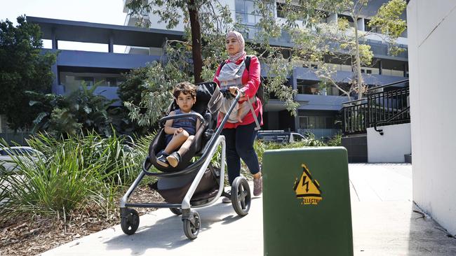 Noor Shamune with her son Mohammad as they walk on the footpath on Bonar Street at Wolli Creek. They have to be mindful of an electrical box that is positioned quite far into the footpath. Picture: Richard Dobson