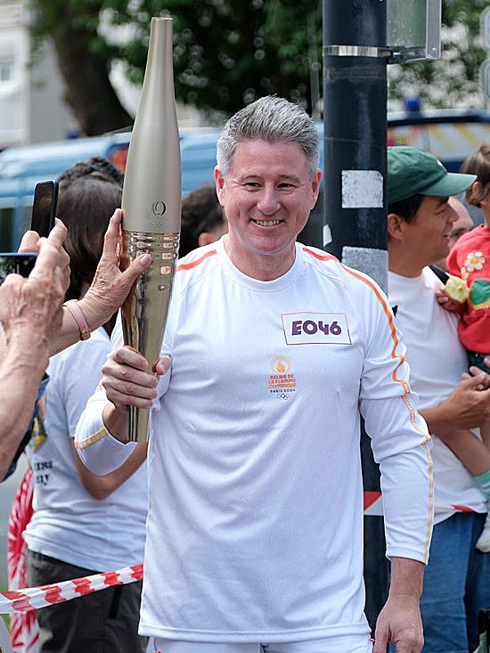 Nine CEO Mike Sneesby carries the Paris Olympics torch in the Olympic torch relay. Picture: Jacquelin Magnay.