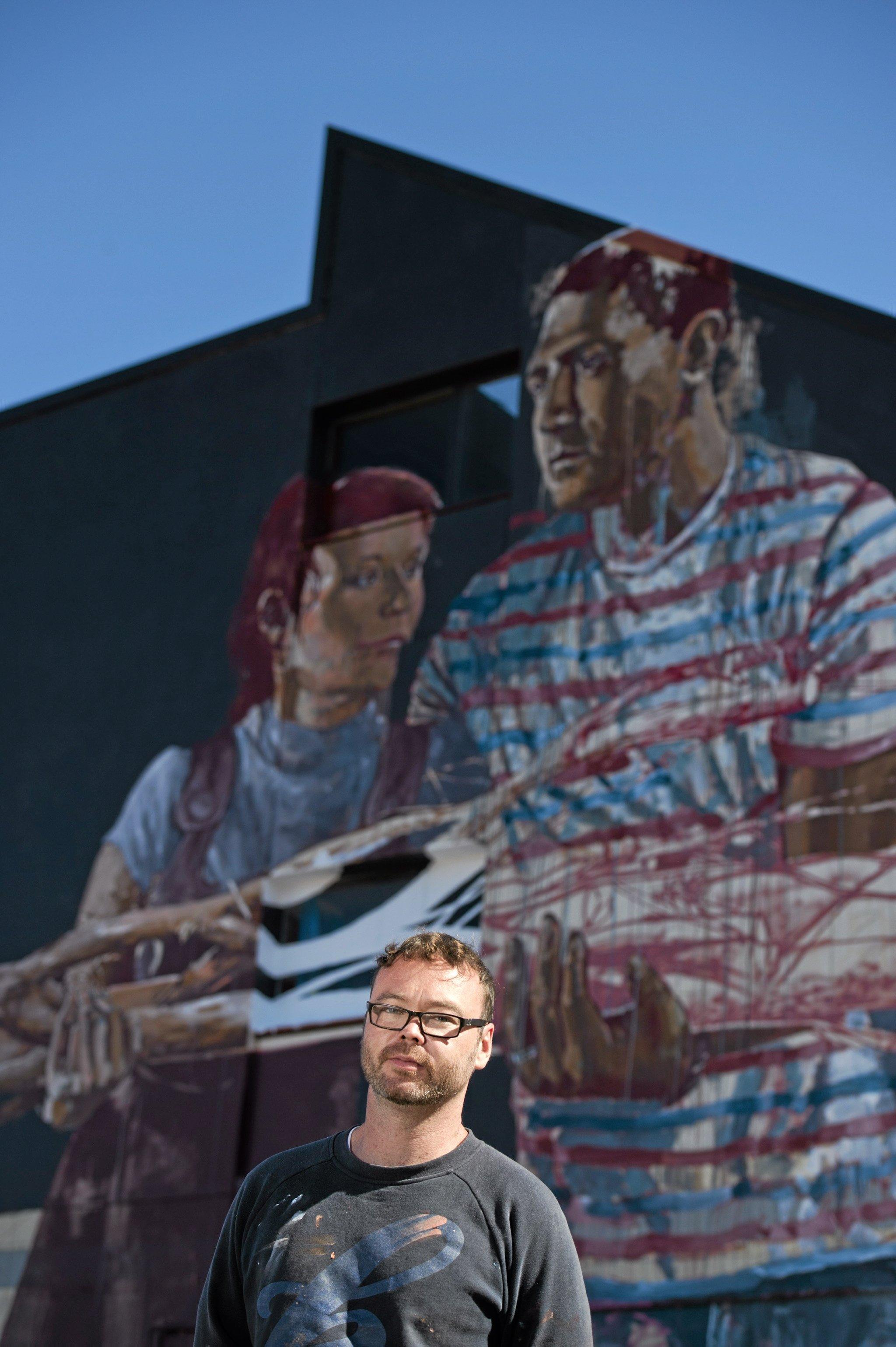 Fintan Magee paints on the SES building wall in Hume St car park for First Coat, Monday, May 30, 2016. Picture: Kevin Farmer