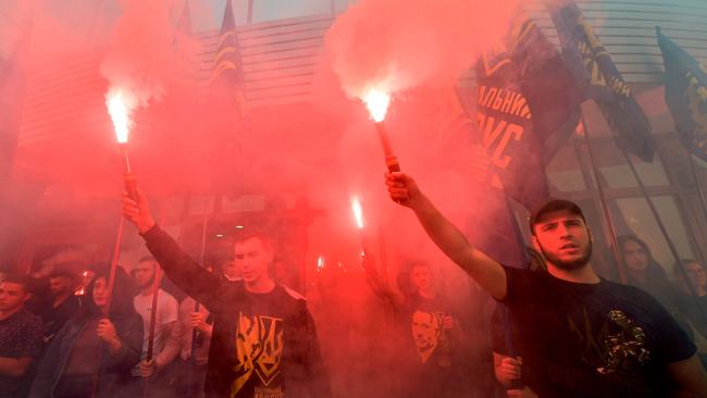 Activists of National Corps, far right Ukrainian party, burn flares during a protest outside the court building after the court freed the man suspected of involvement in the downing of flight MH17. Picture: AFP