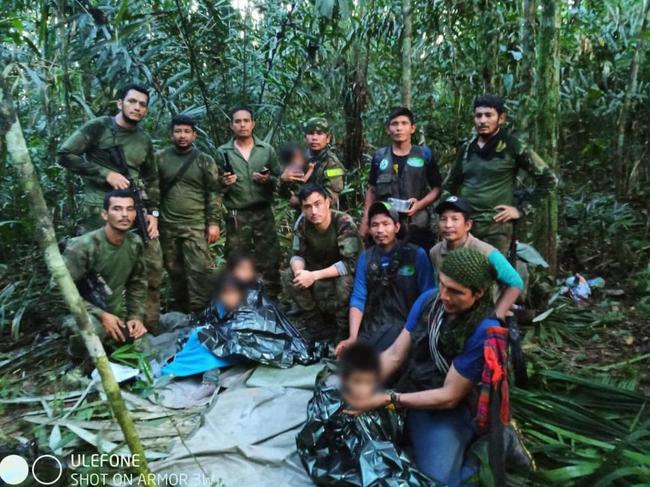 Members of the Army pose with the children after spending more than a month lost in the Colombian Amazon rainforest. Picture: Handout / Colombian Presidency / AFP