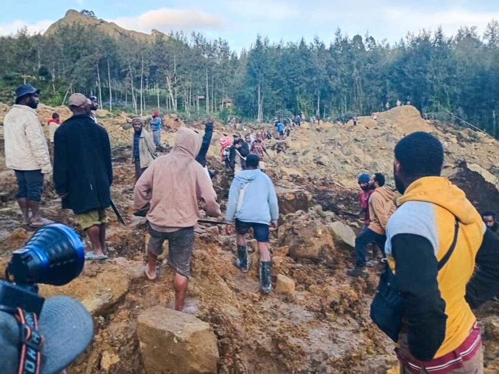 People gather at the site of a landslide in Maip Mulitaka in Papua New Guinea's Enga Province on May 24, 2024. Local officials and aid groups said a massive landslide struck a village in Papua New Guinea's highlands on May 24, with many feared dead. (Photo by AFP)