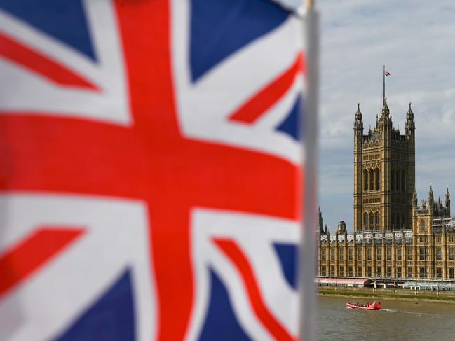 The Palace of Westminster housing the Houses of Parliament is seen from Westminster Bridge with a Union Flag in the foreground in central London on August 28, 2019 - British Prime Minister Boris Johnson announced Wednesday that the suspension of parliament would be extended until October 14 -- just two weeks before the UK is set to leave the EU -- enraging anti-Brexit MPs. (Photo by DANIEL LEAL-OLIVAS / AFP)