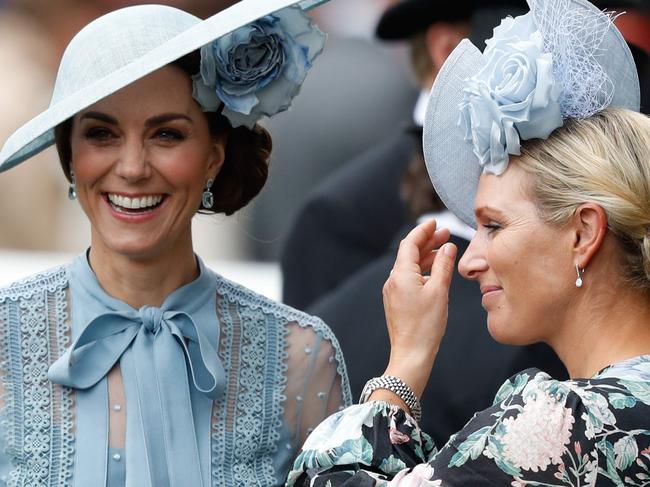 Britain's Catherine, Duchess of Cambridge, (L) and Zara Phillips (R) attend on day one of the Royal Ascot horse racing meet, in Ascot, west of London, on June 18, 2019. - The five-day meeting is one of the highlights of the horse racing calendar. Horse racing has been held at the famous Berkshire course since 1711 and tradition is a hallmark of the meeting. Top hats and tails remain compulsory in parts of the course while a daily procession of horse-drawn carriages brings the Queen to the course. (Photo by Adrian DENNIS / AFP)