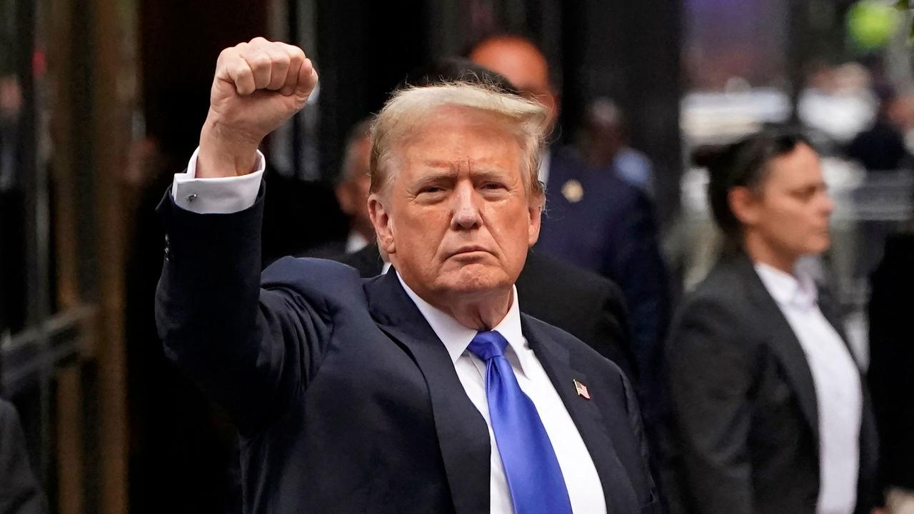 Donald Trump holds up a fist as he arrives back at Trump Tower before going to a fundraiser. Picture: AFP.