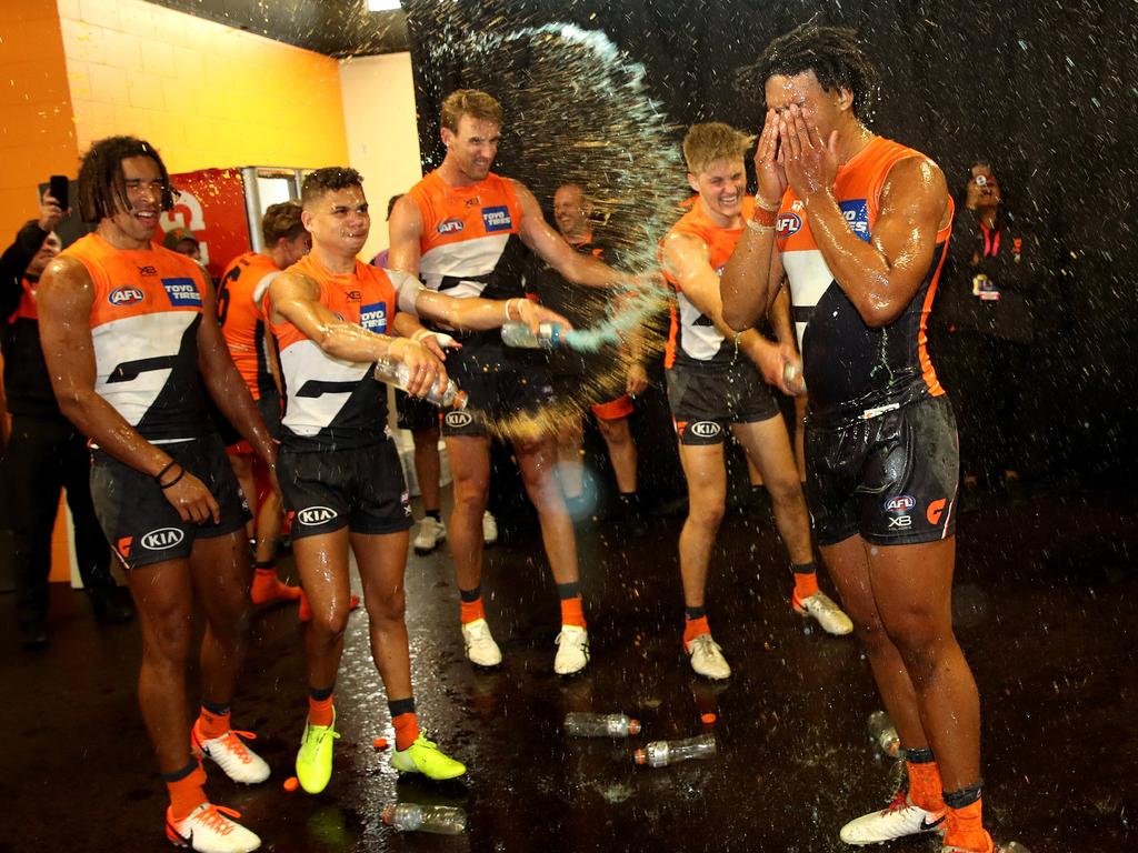 The defender (R) gets drenched as he celebrates his first win in the AFL. Picture: Phil Hillyard