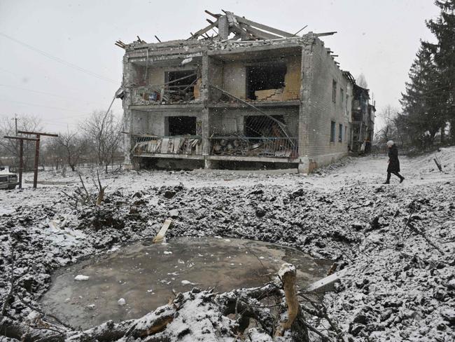 A local resident walks past a crater and a damaged residential building following a recent aerial bombardment in Kupiansk, Kharkiv region. Picture: AFP