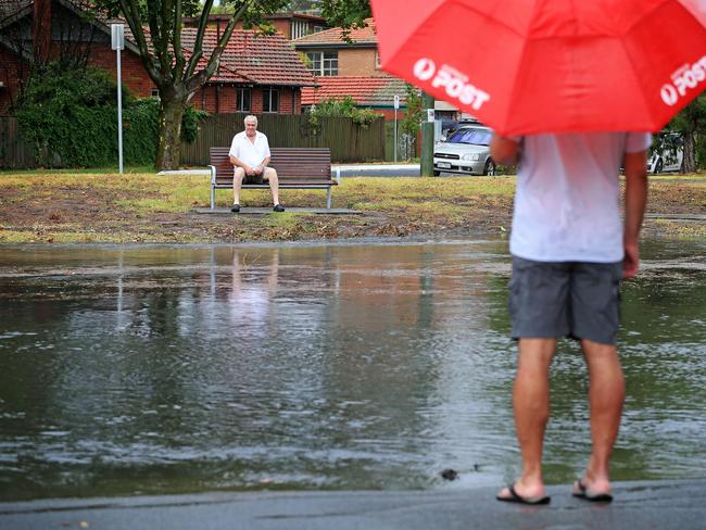 People watch on as the Elster Canal breaks its banks. Picture: Mark Stewart