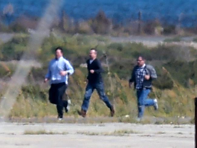 Hostages flee ... passengers on the hijacked EgyptAir Airbus A-320 run on the tarmac after leaving the plane as the highjacker surrendered to security forces. Picture: AFP.