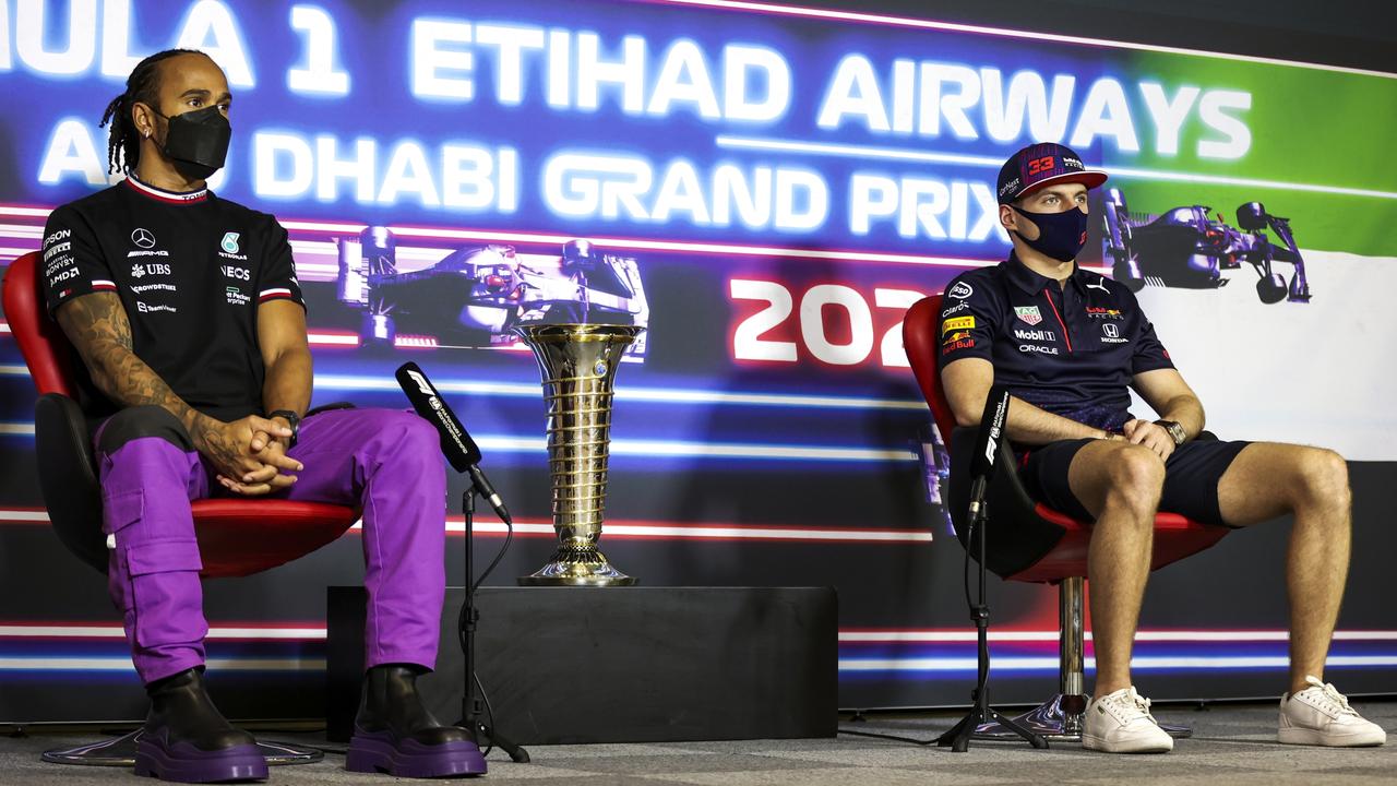 Lewis Hamilton and Max Verstappen, with the all-important F1 trophy between them.