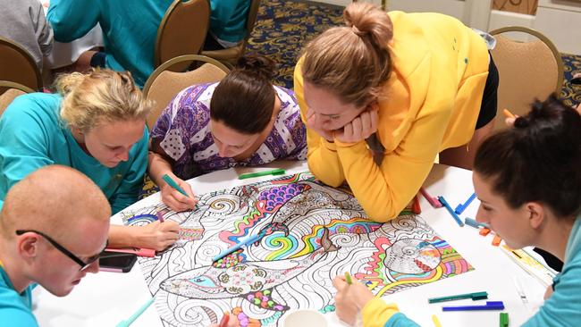 Australian swimming team members doing colouring in at the team hotel during their training camp in Alabama.