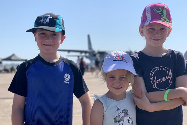 In awe of the planes are (from left) Samuel Grey, 7, Edith Grey, 5, and Isabella Floyd, 8, at the Pitch Black Open Day at RAAF Darwin. Saturday, August 27, 2022. Picture: Tara Miko