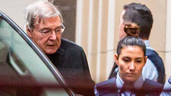 Cardinal George Pell is escorted into the Supreme Court of Victoria today. Picture: AFP