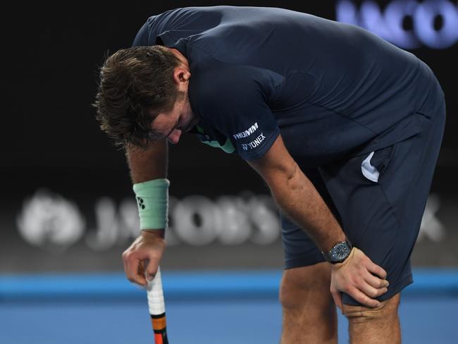 Stan Wawrinka grabs his knee during play against Tennys Sandgren.