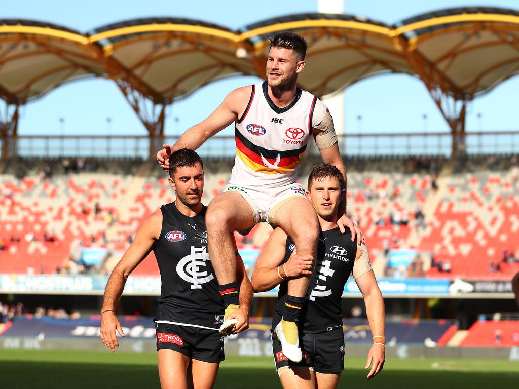 Bryce Gibbs is chaired off by Kade Simpson and Marc Murphy. (Photo by Chris Hyde/Getty Images)