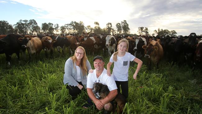 In the thick of it: Angela Turner and Leigh “Skeeta” Verhey with daughter Zara and dog Poppy on their dairy farm at Koondrook.