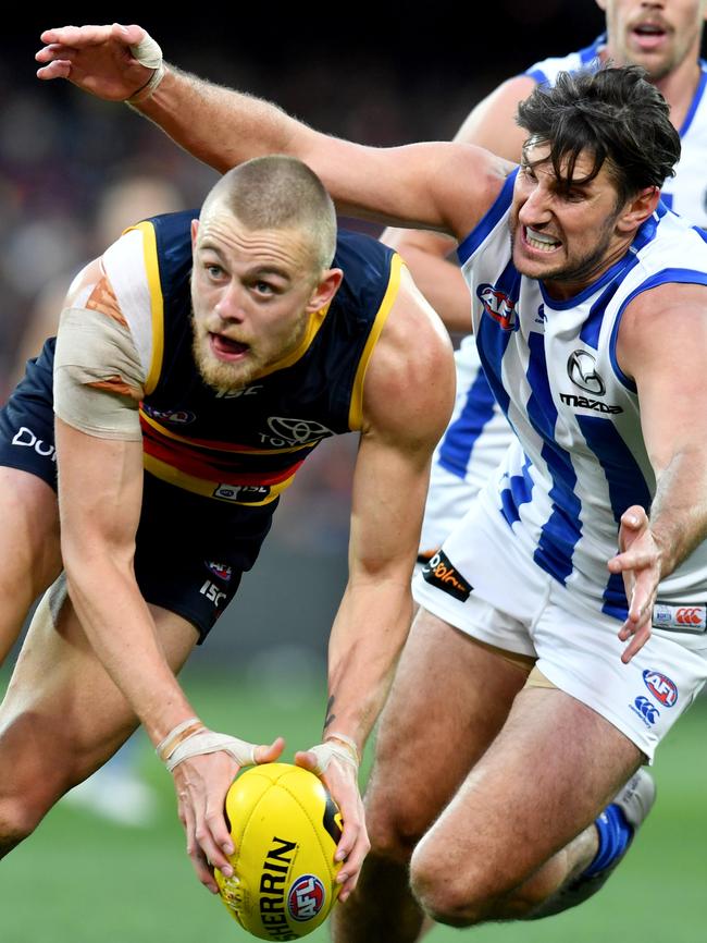 Hugh Greenwood tries to evade the clutches of North Melbourne’s Jarrad Waite. Picture: AAP Image/Kelly Barnes