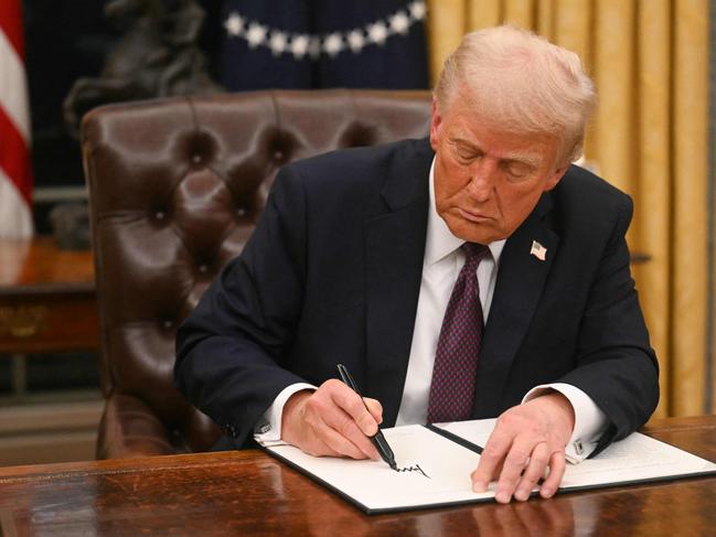 US President Donald Trump signs an executive order in the Oval Office of the WHite House in Washington, DC, on January 20, 2025. (Photo by Jim WATSON / POOL / AFP)