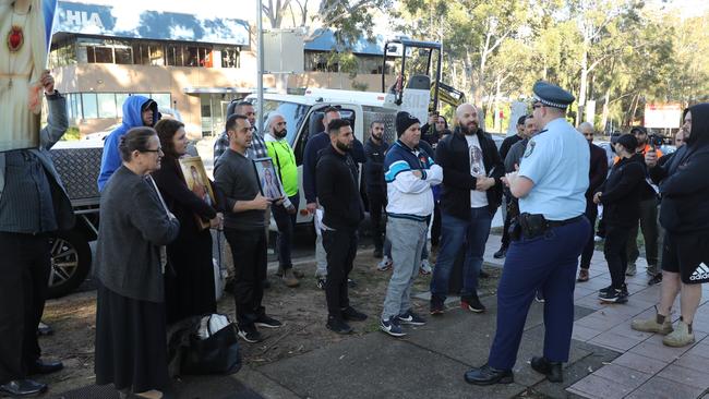 A police officer talks to protesters outside KIIS FM studios this morning. Picture: John Grainger