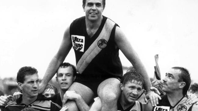 Glenelg footballer Peter Carey is carried from the field by John Seebohm and Chris McDermott after breaking the Australian senior games record in 1988.