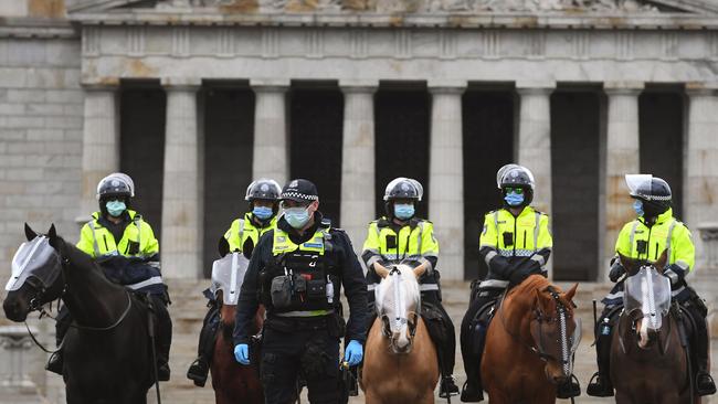 Police stand guard in front of the Shrine of Remembrance during an anti-lockdown rally in Melbourne on Sunday. Picture: AFP