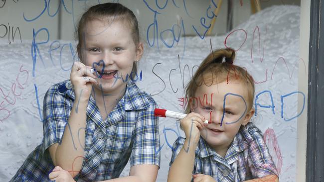 Sisters Saffy, aged 7, and Indie, who is 5, practice their writing everywhere. Picture: David Caird