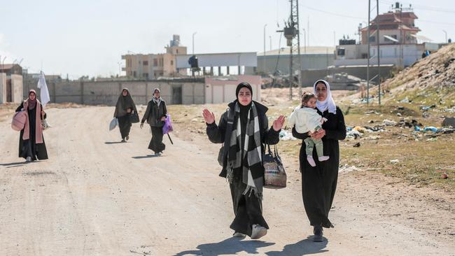 Displaced Palestinian women carrying their belongings, and one lifts a makeshift white flag as they walk past Israeli forces while fleeing Khan Yunis in the southern Gaza Strip. Picture: AFP