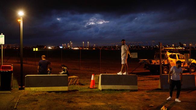 A storm brews in the distance while people watch planes at popular viewing spot at Sydney airport. Sunday 03/12/2023. Picture: Max Mason-Hubers