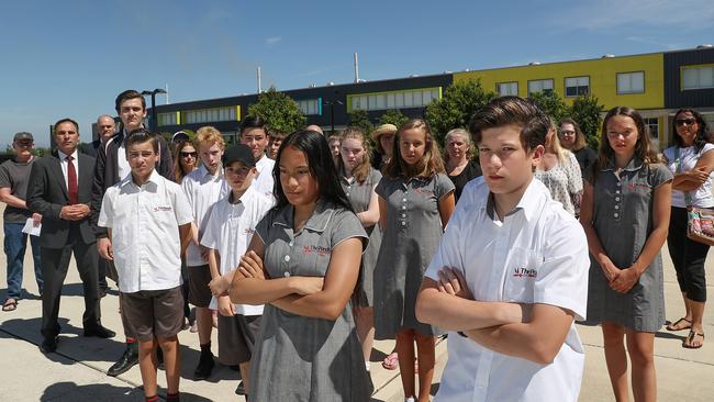 Chesca Chives 13-years and Seth Jude 13-years with parents and other school kids pose for a photo in front of Ponds High School. The school could miss out on airconditioning funding despite an ongoing campaign. (AAP IMAGE / Carmela Roche).