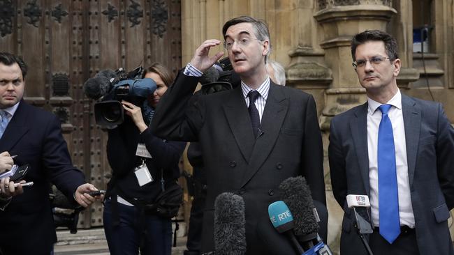 Pro-Brexit, Conservative politician Jacob Rees-Mogg, second right, speaks to the media outside the Houses of Parliament in London.