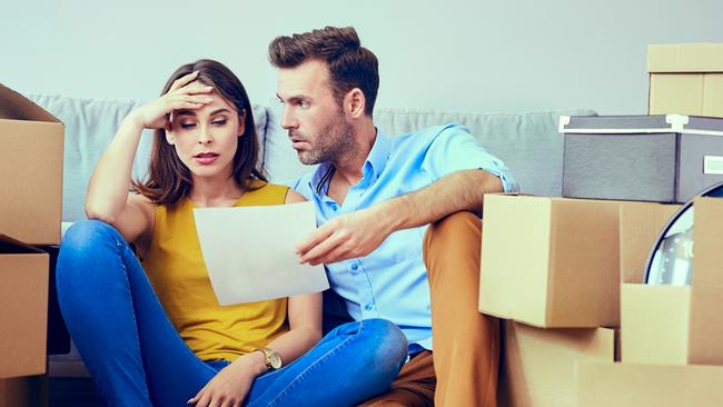 Worried couple reading agreement after moving to new home