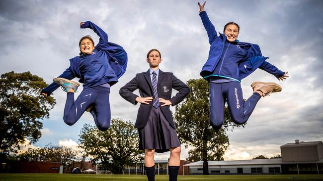 Kingswood College has switched to sports uniforms. Dudman sisters Charlotte, (11) and Issey (13) jump for joy in their new outfits while Lucy Beck (13) wears the old uniform. Picture: Jake Nowakowski