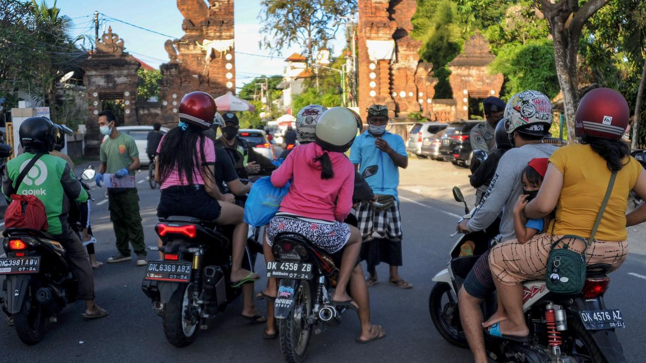 Officers stop people on scooters heading to the beach as new measures are enforced to curb the spread of the Covid-19 in Bali. Picture: Sonny Tumbelaka/AFP